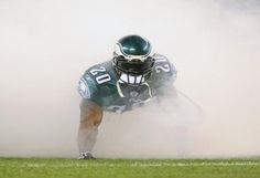 a football player is in the air with his helmet on and one leg bent down