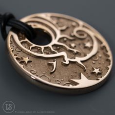 "Rose Gold-plated solid copper pendant with my Celestial Man in the Moon design in deep relief.   The back features my intricate compass rose design.  3mm thick. 32mm diameter, 3mm thick. Comes with a choice of an 18\" leather cord, or an adjustable nylon cord - choker to 30\"." Symbolic Engraved Copper Jewelry, Compass Rose Design, Man In The Moon, Deep Relief, In The Moon, Compass Rose, Sun And Stars, Copper Pendant, Moon Design