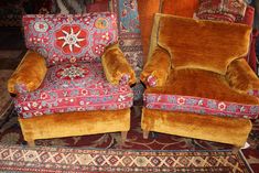 two brown chairs sitting next to each other on top of a rug