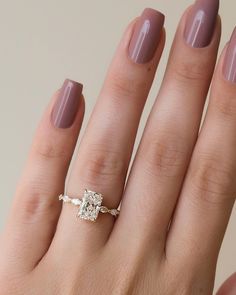 a woman's hand with a ring on it and a diamond in the middle