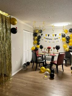 a party room with balloons and streamers on the wall, tables and chairs are set up for a celebration