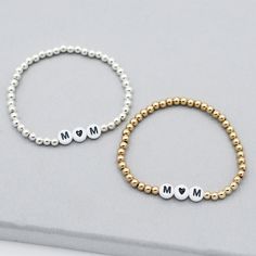 Add a little love to mom’s stack! Bracelet is made with 4mm sterling silver or 14k goldfill beads with “mom” in the center spelled with a heart. Easy wear and effortless bracelet stacking with stretch cord design Sizing options to make sure you have the perfect bracelet fit. Please contact us if you have any sizing questions or would like a custom size. Minimalist Letter Beads Jewelry For Anniversary, Dainty Letter Beads Jewelry For Anniversary, Mother's Day Name Bracelet With Letter Beads, Anniversary Sterling Silver Jewelry With Letter Beads, Dainty Personalized Beaded Bracelets For Mother's Day, Personalized Dainty Beaded Bracelets For Mother's Day, Silver Letter Beads Jewelry For Mother's Day, Mother's Day 8mm Beaded Bracelets, Silver Beaded Bracelets For Everyday And Mother's Day