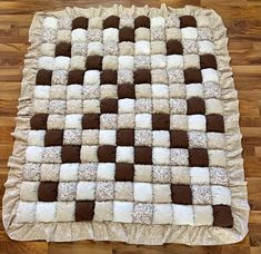 a brown and white patchwork rug on a wooden floor