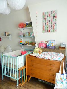 a baby's room with a crib, changing table and bookshelf