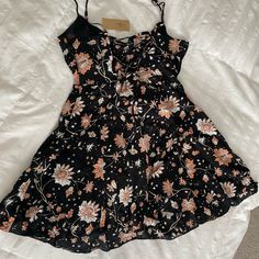 This Is A Dress From American Eagle Outfitters New With Tags Women's Size 4 Black With White And Pink Floral Pattern Adjustable Spaghetti Straps Mini Length Side Zipper Closure Criss Cross Tie In Back Summer Dress Measures Approx 15 Inches Across Bust Measures Approx 30 Inches In Length Casual Mini Suspender Dress With Floral Print, Spring Black Floral Mini Dress, Summer Mini Dress With Adjustable Cross-back Straps, Black Floral Print Sleeveless Sundress, Black Floral Print Summer Mini Dress, Babydoll Style Dress, Strapless Sundress, American Eagle Dress, Tie Dye Mini Dress