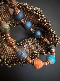 This stretch bracelet is comprised of paper beads from Uganda, blue druzy agate and copper beads.  The small copper rings are African metal beads. Druzy stones are actually a small crystal formation on a layer of stone. They are a collection of very small crystals, like the inside of a geode but on a much smaller scale and usually on an open surface.  It is said that druzy enhances the power of the natural defense system of the human body and gives strength to the spirit. Paper beads are the old Handmade Copper Beaded Bracelets, Handmade Copper Beaded Bracelets With Round Beads, Spiritual Copper Bracelets With Round Beads, Bohemian Blue Spacer Beads, Blue Copper Round Bead Jewelry, Blue Copper Round Beads Jewelry, Blue Hand-strung Stretch Bracelet, Hand-strung Bohemian Czech Glass Stretch Bracelet, Crystal Formations