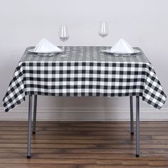 a black and white checkered tablecloth with two wine glasses on the top one