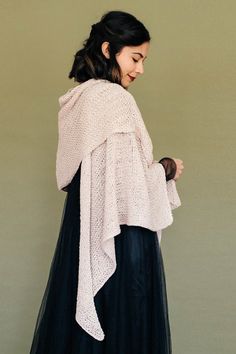 a woman in a black and white dress is wearing a shawl