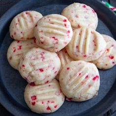 a plate full of cookies with red sprinkles