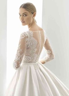 a woman in a white wedding dress looking back at the camera with her hands on her hips