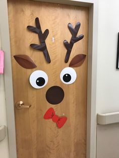 a door decorated to look like a reindeer with antlers on its nose and bow tie