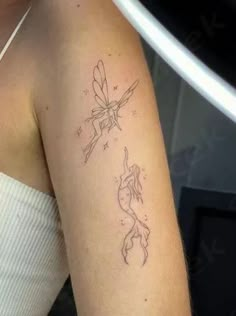 a woman's arm with a tattoo on it that has a dragon and firefly