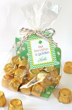 a bag filled with gold foiled chocolates next to some small pieces of candy