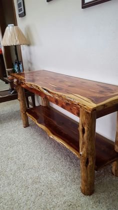 a wooden bench sitting next to a lamp on top of a carpeted room floor