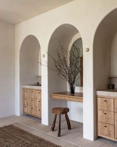 a bathroom with an arched wall and wooden furniture