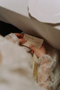 a woman is holding a note in her hand