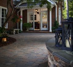 the front entrance to a home with brick walkway and pillars leading up to it's entry door