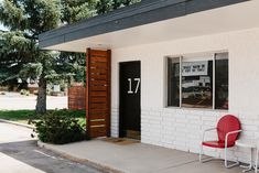 a red chair sitting in front of a white building