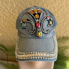 Denim Hat With Multi Color Jewels On Brim And Front. Adjustable Size. Never Worn. Trendy Rhinestone Hats For Spring, Casual Silver Hat, One Size Fits Most, Silver Casual Hat, Casual Silver Hat One Size, Casual Silver Hat, Blue Adjustable Hat With Rhinestones, Adjustable Blue Hat With Rhinestones, Spring Hats With Rhinestones, Spring Rhinestone Hats