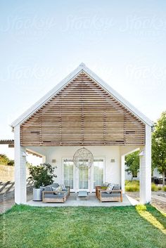 an outdoor living area with two couches and a pergolated roof over it