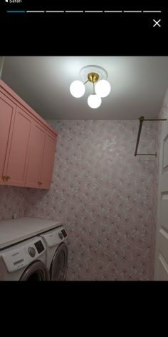 an image of a laundry room with pink cabinets and washer dryer in it