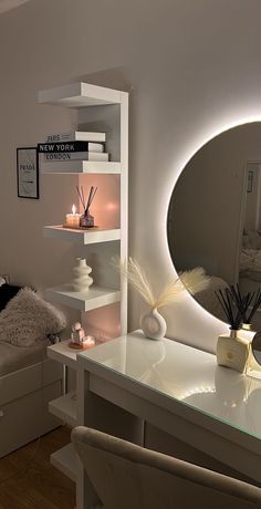 a white desk topped with a mirror next to a bed