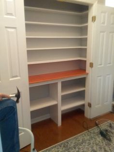 a person sitting on a chair in front of a book shelf with an open door