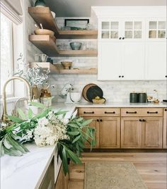 a kitchen with wooden cabinets and white marble counter tops