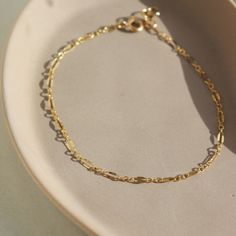 Timeless with a vintage style, the Sylvie Bracelet adds a little sparkle to your wrist! This bracelet is ideal for stacking amongst bolder chains like our Demi Alex or wear it alone for an easy elevated look. DETAILSBracelet Sizing: XS= 5.5", S=6", M=6.5", L=7", XL=7.5".5" adjustable spring hook clasp To measure your wrist size, wrap a piece of string around your wrist the way you would like the bracelet to fit. Then lay the string flat and measure the inches to get your size. Each piece of Toke 14k Gold Figaro Chain Bracelet For Everyday, Everyday 14k Gold Bracelet With Figaro Chain, Everyday 14k Gold Figaro Chain Bracelet, Dainty Gold Bracelet With Extender, Everyday 14k Gold Delicate Chain Bracelet, Dainty 14k Gold Bracelet With Extender, Dainty Oval Link Bracelet For Everyday, Delicate 14k Gold Chain Bracelet For Everyday, Classic 14k Gold Filled Bracelet With Delicate Chain