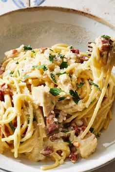 a white bowl filled with pasta and meat