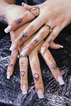 two people with tattoos on their hands and fingers