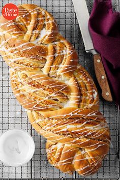 a large loaf of bread sitting on top of a cooling rack next to a knife