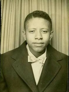 an old black and white photo of a young man in a suit with a bow tie