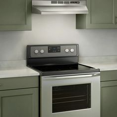 a stove top oven sitting inside of a kitchen next to green cupboards and counter tops