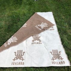 two towels laying on the grass with an iceland logo printed on them and one towel folded over it