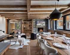 a living room filled with furniture and a fire place next to a dining table in front of a fireplace