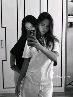 two women are taking a selfie in black and white