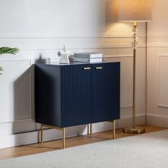 a blue cabinet sitting next to a lamp on top of a rug in a living room