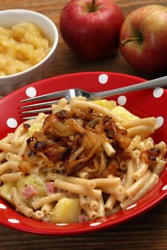 a red plate topped with pasta next to two bowls of macaroni and cheese