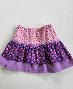 Cotton tiered skirt with rick rack trim. Tiers are purple and pink cotton prints and purple embroidered corduroy. -This is a size 3 skirt. -measures approx 11 inches long. -100% cotton -All seams are professionally finished. -Made in smoke free environment. * Care Machine wash in cold water Machine dry cool or line dry. Touch up with an iron if needed. **CUSTOM ORDERS** Every item in the shop is one of a kind (OOAK) **If you see something you like, but it's not the size that you need...let us kn Cute Purple Cotton Bottoms, Cotton Tiered Lined Skirt, Tiered Cotton Lined Skirt, Tiered Lined Cotton Skirt, Pink Cotton Skirted Bottoms, Tiered Cotton Skirt With Lining, Cute Cotton Ruffle Skirt, Cute Cotton Ruffled Skirt, Playful Fitted Purple Bottoms