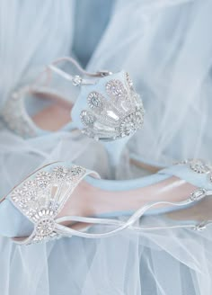 a pair of white wedding shoes on top of a bed