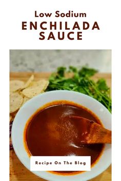 a bowl of enchilada sauce with tortilla chips on the side