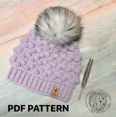 a crocheted hat with a fur pom