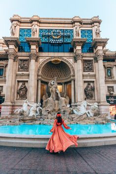 a woman standing in front of a fountain