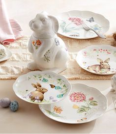 a table topped with plates and dishes covered in bunny design on top of a table