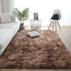 a living room with a large rug on the floor and a white couch in front of it