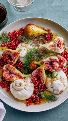 a white plate topped with meat covered in pomegranate and garnish