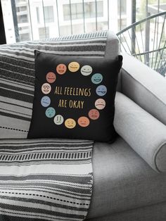 a pillow that says, all feelings are okay on a couch in front of a window