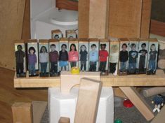 a group of children's pictures are placed on a wooden shelf in the middle of a cluttered room