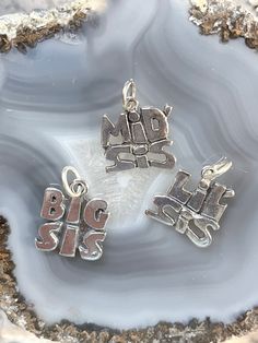 Sterling Big Sis charm, Sterling Mid Sis charm, Sterling Lil sis charm, Sterling Sister charm, Silver family charms, sterling Sorority charm Please view ALL pics for size and details Charms may pose a choking hazard These Sterling Sister charms are a perfect gift for a sibling or for that special Sorority sister!  Each charm is a bit  heavier weight and would be beautiful on a sterling silver chain or attached to your favorite charm bracelet. Our charms can be paired with your unique stampings, Personalized Silver Charms For Mother's Day, Sterling Silver Pendant Charms For Mother's Day, Collectible Nickel-free Sterling Silver Charms, Silver Charms For Mother's Day Personalized Gift, Personalized Sterling Silver Charms For Collectors, Silver Dangling Charms For Mother's Day, Sterling Silver Dangling Charms For Personalized Gifts, Mother's Day Silver Dangling Charms, Personalized Sterling Silver Charms For Mother's Day